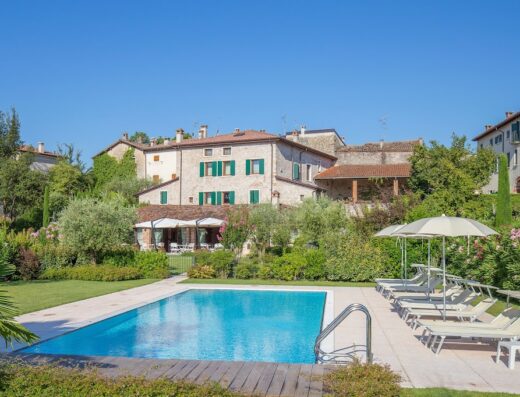 Antico Casale Bergamini, Italy: Vista della piscina privata con lettini prendisole, giardino curato e l'architettura storica della villa.