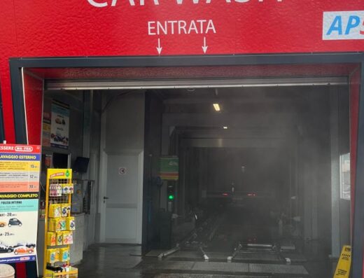 Ingresso di un autolavaggio con insegna "Car Wash", "Entrata" e il logo AP5. Sono visibili i listini prezzi per i programmi di lavaggio auto.