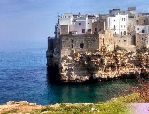 Veduta panoramica di Polignano a Mare, Puglia. Suggestiva cittadina con case bianche a strapiombo sul mare Adriatico. Escursioni e vacanze in moto in Puglia con Apulia 70 Holidays.
