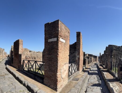 Strada antica con resti di edifici in mattoni a Pompei, Italia, un sito storico e destinazione turistica popolare per tour e viaggi.