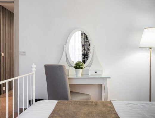 Arredamento interno di Aulino House con specchiera bianca, sedia grigia, lampada da terra e letto matrimoniale, per un soggiorno confortevole e rilassante.