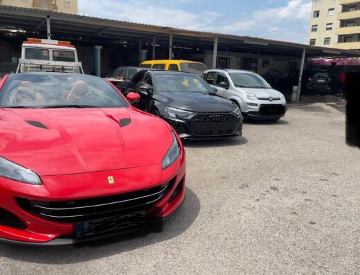 Auto lavaggio a mano i 4 fratelli: primo piano di una Ferrari rossa, un'Audi nera e una Fiat Panda bianca parcheggiate.