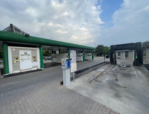 Auto lavaggio Speedy Wash: vista esterna della stazione di lavaggio auto con struttura verde e box per il lavaggio self-service.