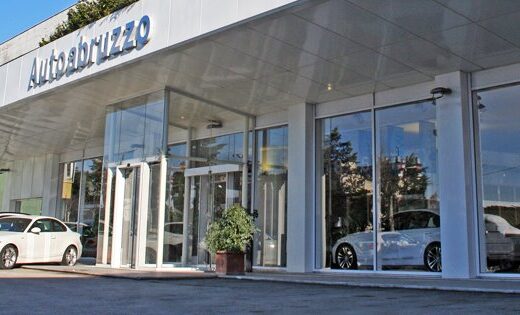 Autoabruzzo Srl BMW, BMW Motorrad e Partner MINI concessionaria a Pescara con auto BMW parcheggiate di fronte all'edificio.
