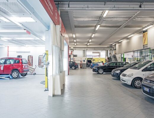 Interno di Autocarrozzeria Fagioletti con auto in riparazione e vetture in attesa di intervento. Servizi di carrozzeria e verniciatura.