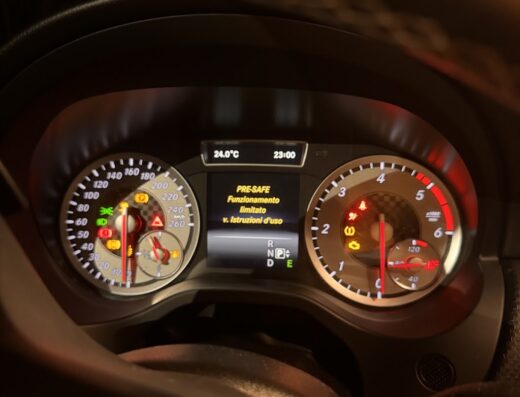 Cruscotto auto che mostra un avviso di "PRE-SAFE Funzionamento limitato". Dettaglio del quadro strumenti con spie accese e indicazioni di velocità e giri motore.