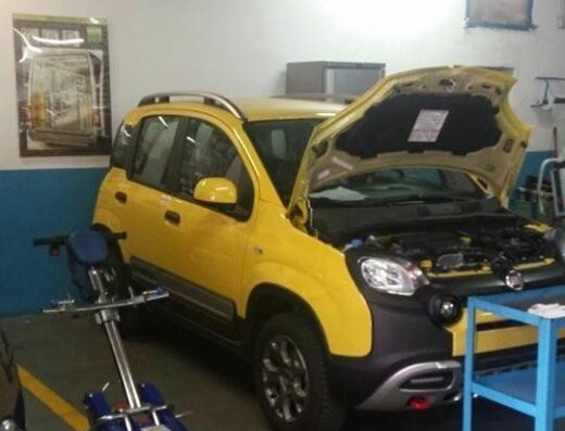 Autofficina Meccatronica Marsalone Palermo: Fiat Panda gialla con cofano aperto per manutenzione, attrezzi diagnostici e carrello officina visibili.