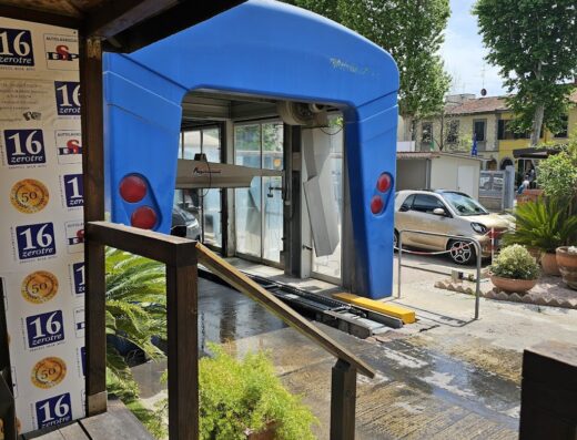 Autolavaggio Dps di De Pascalis Stefano: Vista di un moderno autolavaggio automatico con struttura blu, visibile dalla pedana in legno. Servizi di lavaggio auto professionali.