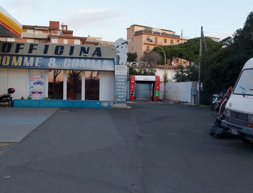 Autolavaggio e officina gomme in Italia, con moto parcheggiata. Servizi di lavaggio moto e riparazione pneumatici disponibili.