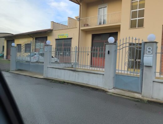 Autolavaggio a mano: Facciata di un edificio con recinzione e numeri civici, potenziale servizio di lavaggio moto e accessori.