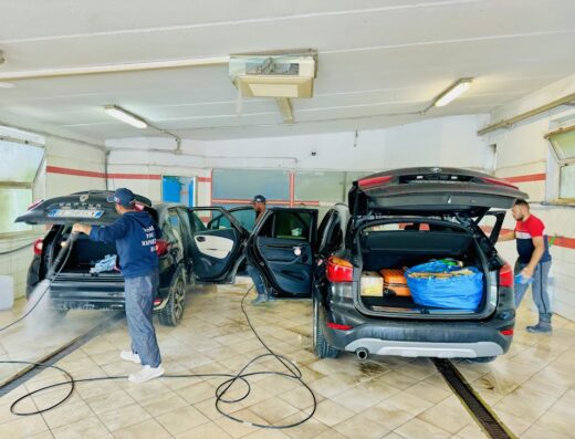 Autolavaggio a mano Amici (SAFI): Persone che lavano auto con portabagagli aperti, evidenziando il servizio di pulizia e cura auto.