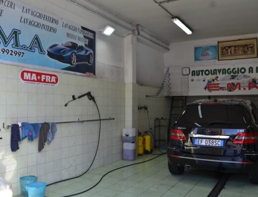 Interno di Autolavaggio A Mano EMA con Mercedes B200 CDI in attesa di lavaggio auto, idropulitrice, prodotti Ma-Fra, cartello lavaggio moto e motore