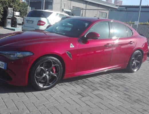 Alfa Romeo Giulia rossa appena lavata presso Autolavaggio A Mano L.A., dettaglio della carrozzeria lucida e cerchi in lega.