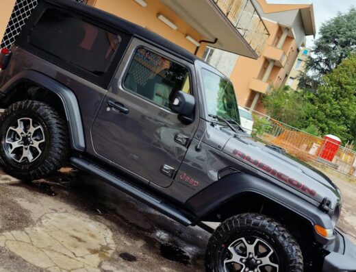 Autolavaggio a mano senza rulli a Forlì: Jeep Rubicon grigia pulita e splendente dopo il lavaggio, dettaglio degli pneumatici e della carrozzeria.