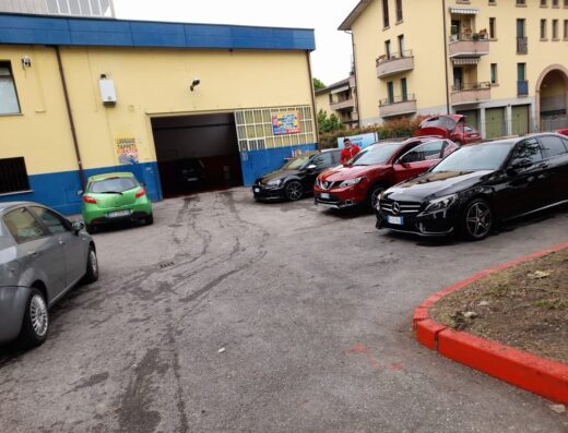 Autolavaggio a mano senza rulli a San Maurizio Canavese: fila di auto in attesa del lavaggio, inclusi modelli Mercedes-Benz e Nissan, presso l'autolavaggio.