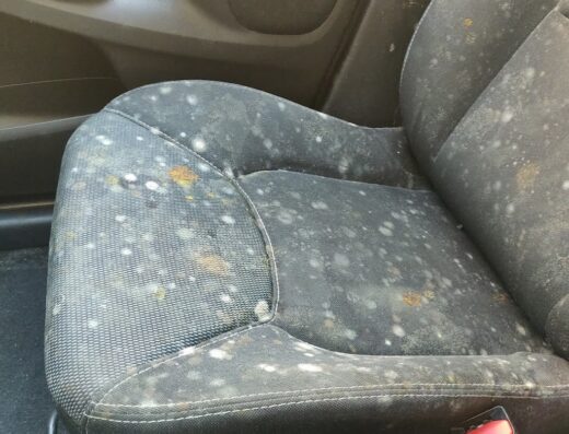 Sedile auto in tessuto nero gravemente sporco e macchiato, necessita di autolavaggio a mano professionale Turbo Wash.