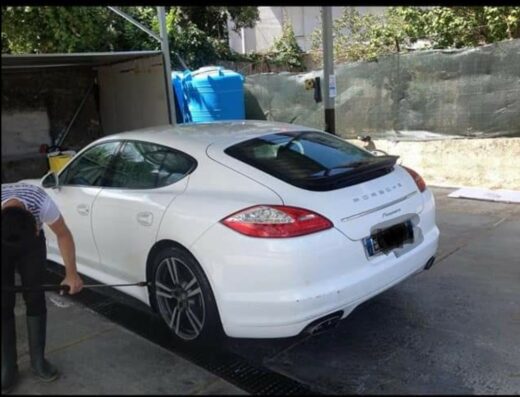 Autolavaggio acqua jet: Dettaglio di una Porsche bianca in fase di lavaggio con idropulitrice. Servizio di pulizia auto professionale.