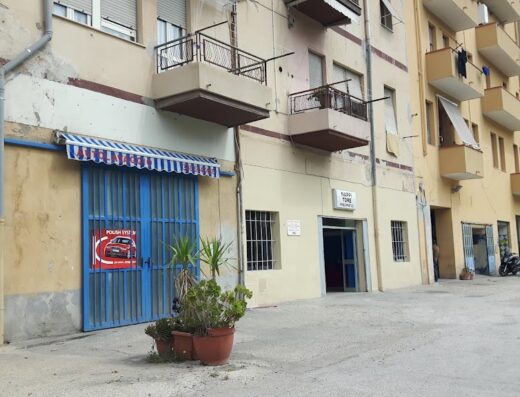 Autolavaggio Adamo, un servizio di lavaggio moto e auto a Campobello di Licata. Veduta esterna con insegne e moto parcheggiate.