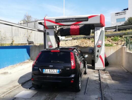 Autolavaggio Atc188: Un'auto nera in un autolavaggio automatico, con spazzole rotanti rosse e nere pronte a pulire il veicolo.