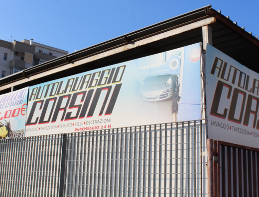 Insegna dell'autolavaggio e autonoleggio Corsini che offre servizi di lavaggio auto, pulizia tappezzeria, tessuti, pelle, decorazioni e parcheggio 24 ore su 24