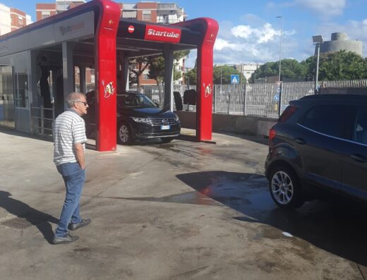 Autolavaggio automatico Startube a San Marcello, con auto in attesa di lavaggio e un uomo in piedi nelle vicinanze.