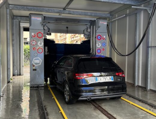 Autolavaggio Balena: Auto nera in un impianto di lavaggio automatico, dettaglio del servizio di pulizia veicoli.