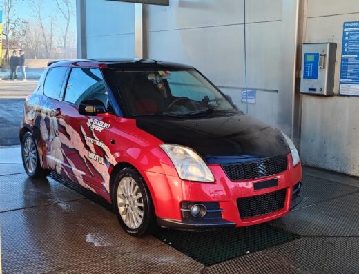 Autolavaggio Brilli: Suzuki Swift rossa e nera con decorazioni personalizzate, in un autolavaggio self-service.