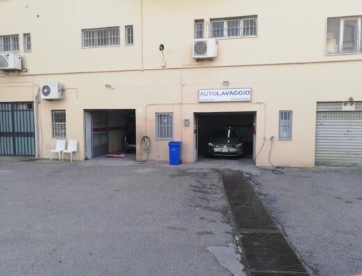 Autolavaggio Da Giacomo exterior, showing car wash bays with vehicles inside, car service business in Italy.