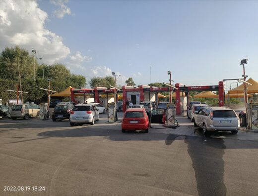Autolavaggio dello Sterpeto: Diverse auto in fila per il lavaggio auto self-service in una stazione di servizio con cielo sereno.