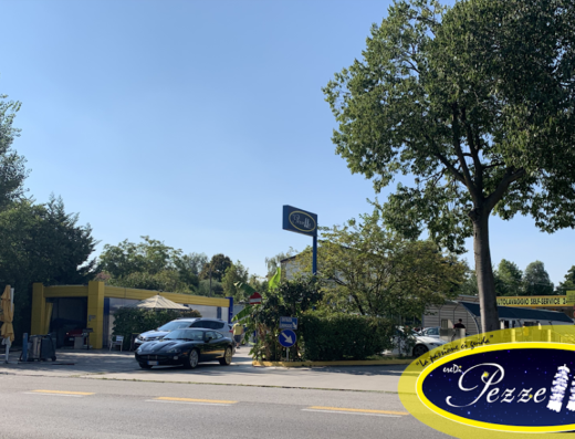 Vista esterna dell'autolavaggio Eredi Pezzella Agostino, con auto in attesa di lavaggio e insegna ben visibile. Servizio di autolavaggio self-service.