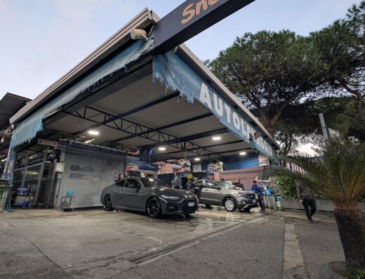 Autolavaggio Fratelli Iavarone: vista esterna dell'autolavaggio con auto in fase di lavaggio. Servizi professionali per la cura dell'auto.