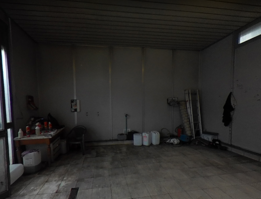 Interno di Autolavaggio Il Faraone con attrezzature, contenitori e accessori per la pulizia di moto e veicoli, spazio di lavoro illuminato.