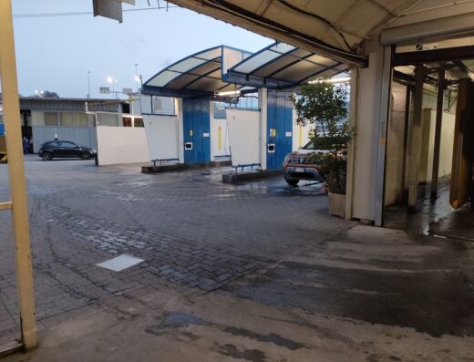 Autolavaggio Le Torri: Veduta esterna dell'autolavaggio con auto in attesa di lavaggio e box di lavaggio auto.