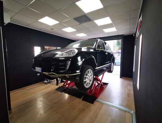 Autolavaggio Max: Porsche Cayenne nera su ponte sollevatore per lavaggio e detailing auto professionale.