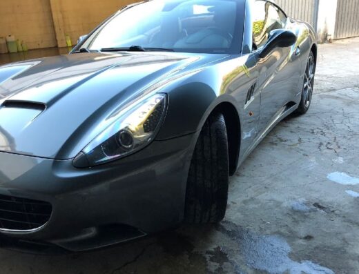 Dettaglio di una lussuosa Ferrari grigia presso Autolavaggio Puccini 28, che mostra la cura e l'attenzione ai dettagli nel servizio di lavaggio auto.