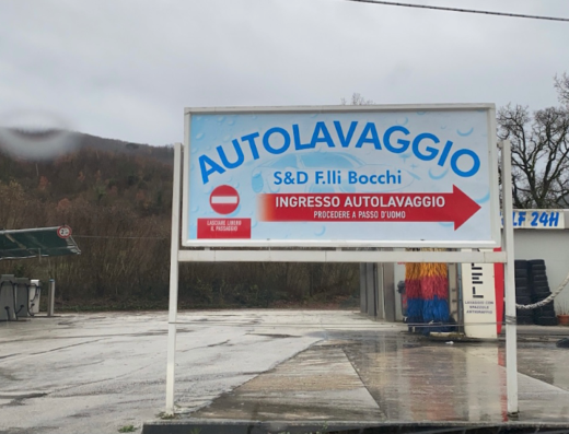 Insegna dell'Autolavaggio S&D F.lli Bocchi, un servizio di lavaggio auto professionale. L'insegna indica l'ingresso con una freccia rossa e le indicazioni per l'accesso.