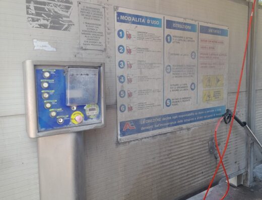 Autolavaggio self-service: dettaglio del pannello di controllo e delle istruzioni per il lavaggio di moto e altri veicoli.