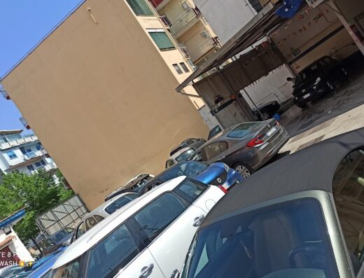 Autolavaggio Starwash: Cars awaiting carwash service in Naples, Italy. View of several vehicles parked outside the Starwash car wash, including a convertible and other cars.