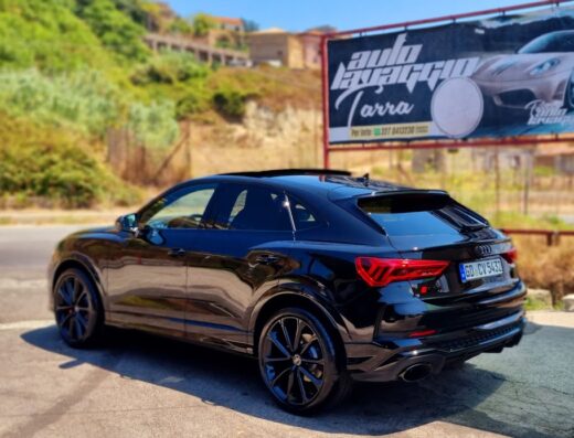 Autolavaggio Tarra: elegante Audi Q3 nera appena lavata, parcheggiata di fronte all'autolavaggio con insegna ben visibile.