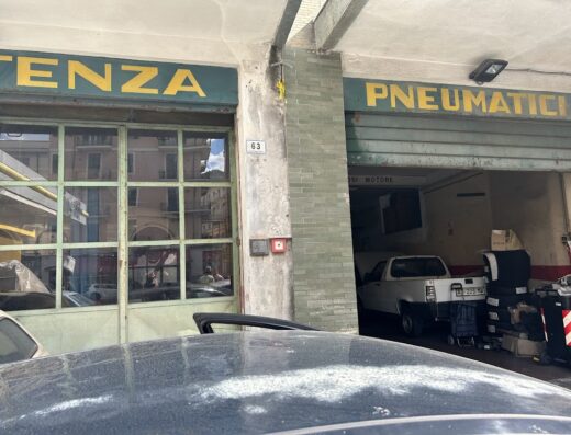 Automeccanica di Mauro Pennacino: Facciata dell'officina con insegne 'TENZA' e 'PNEUMATICI', numero civico 63, e veicoli parcheggiati. Servizi di riparazione e manutenzione moto.