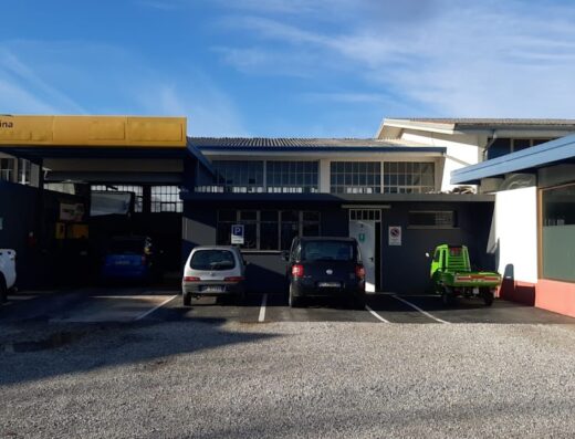 Immagine dell'officina Automotori S.r.l. con auto parcheggiate, offre servizi di riparazione moto e accessori per motociclisti.