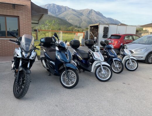Flotta di scooter e moto a noleggio presso Beep-Beep Della Maggiori Rent Car Srl, con diversi modelli e colori disponibili per esplorare la zona.