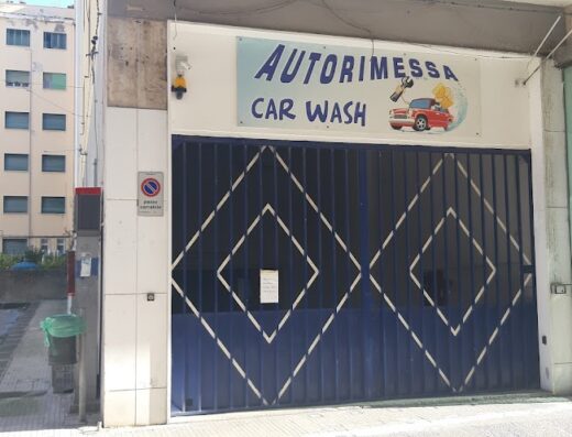 Foto dell'ingresso di Autorimessa Car Wash a Siracusa, con saracinesca blu decorata e insegna che pubblicizza il servizio di autolavaggio.