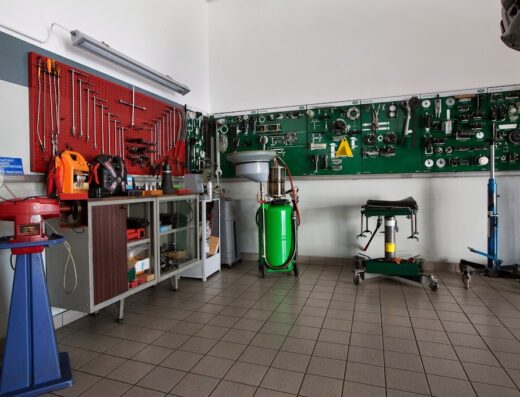 Interno dell'officina Autoriparazioni Borgnalle con attrezzature per la riparazione di moto, utensili appesi e pavimento piastrellato.