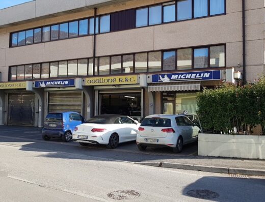 Foto dell'edificio di Avallone Renato & C. Snc, specialista in pneumatici per moto e auto, con insegne Michelin e Yokohama. Sono visibili diverse auto parcheggiate di fronte.