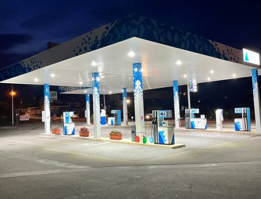 Distributore Azzalini di benzina e metano con servizio di autolavaggio a Belluno, illuminato di notte, ideale per rifornimento moto e auto durante un viaggio.