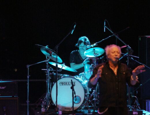 Esibizione musicale al Baloma Bikers Festival: un batterista suona la batteria Volume mentre un cantante si esibisce con un microfono.