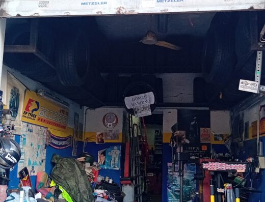 Un'officina specializzata in pneumatici per moto e servizi correlati, con l'insegna "Bandino Rivenditore Specializzato Metzeler", attrezzature e accessori visibili.