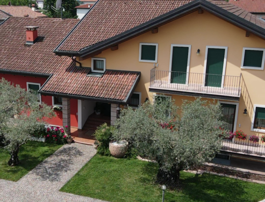 B&B agli Ulivi: Vista aerea della facciata esterna di una casa vacanze con giardino curato e vialetto pavimentato, ideale per un soggiorno rilassante.