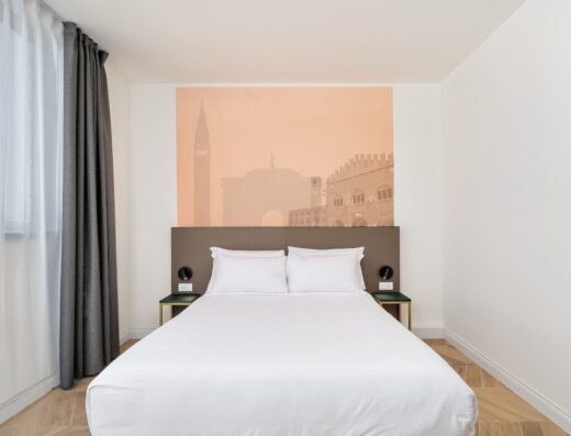 Camera dell'hotel B&B Treviso Al Fogher con letto matrimoniale, comodini e vista sulla città di Treviso.